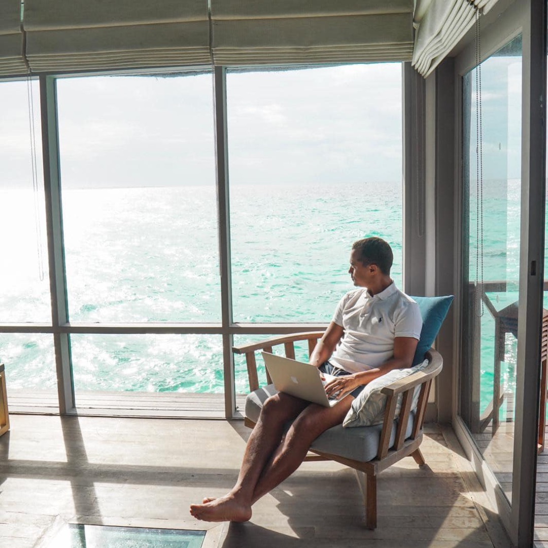 Samba Diagne working, ocean beyond the window