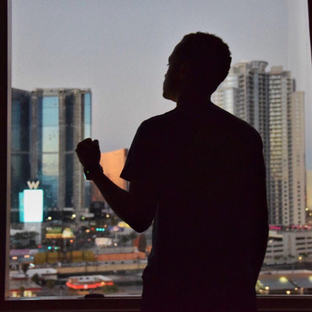 Samba Diagne at the window over a night skyline